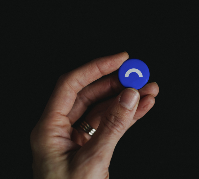 Hand Holding Pin Button Mockup Copy 1